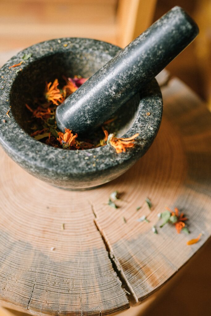 image of mortar and pestle crushing plants/herbs is characteristic of a homesteading life