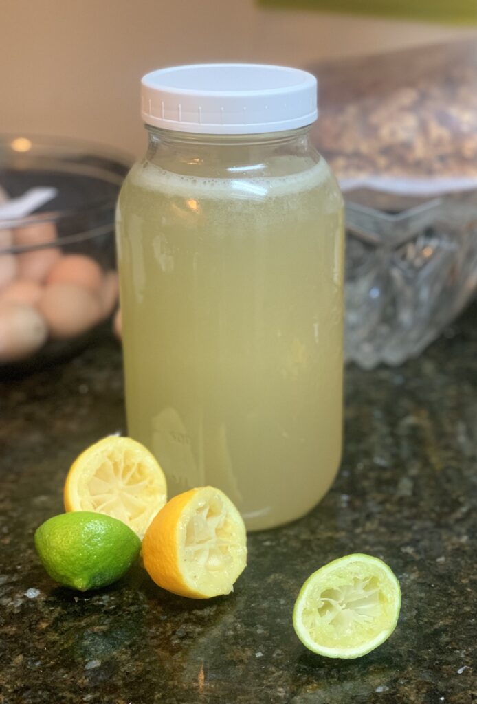 cup of lemonade with sprigs of herbs, wedges of citrus and ice represents a refreshing boost of energy drink