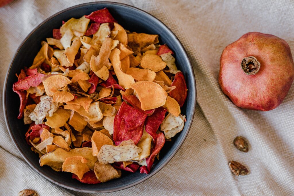dehydrated veggie & apple slices of various shades of red, white and pink in a bowl are the perfect way to preserve produce at home