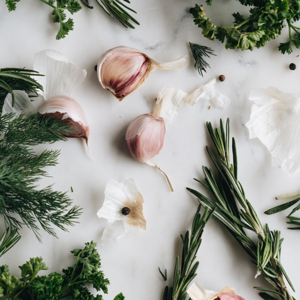 rosemary, dill, parsley, garlic cloves & peppercorns are an example of herbs and spices, some of the essential pantry staples in a self-sufficient kitchen.