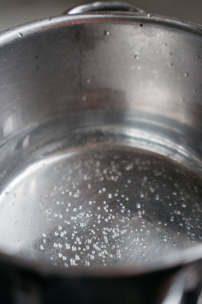 silver pot filled with simmering water & tiny bubblesc