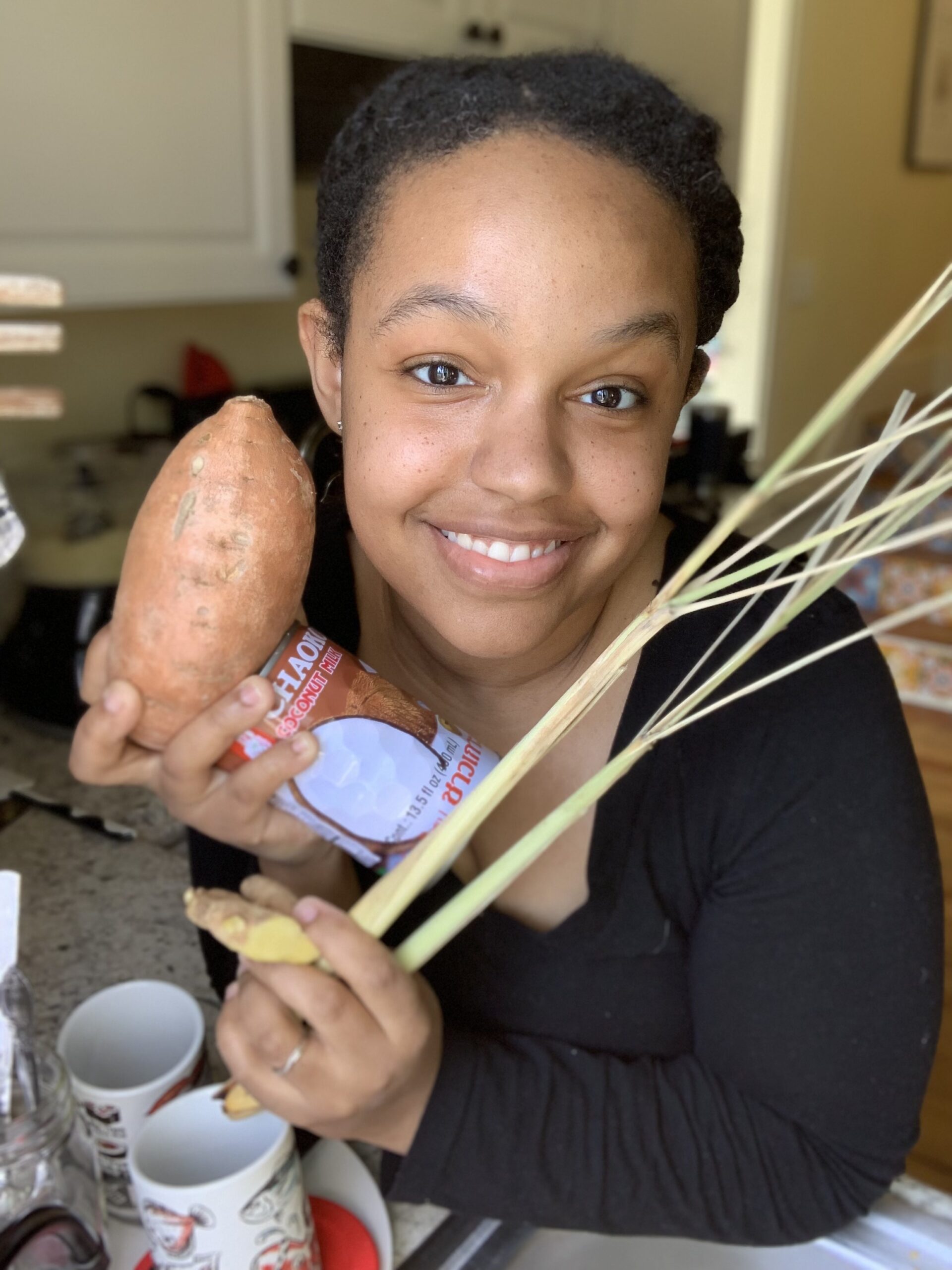 brown girl holding ingredients used to make a globally inspired meal