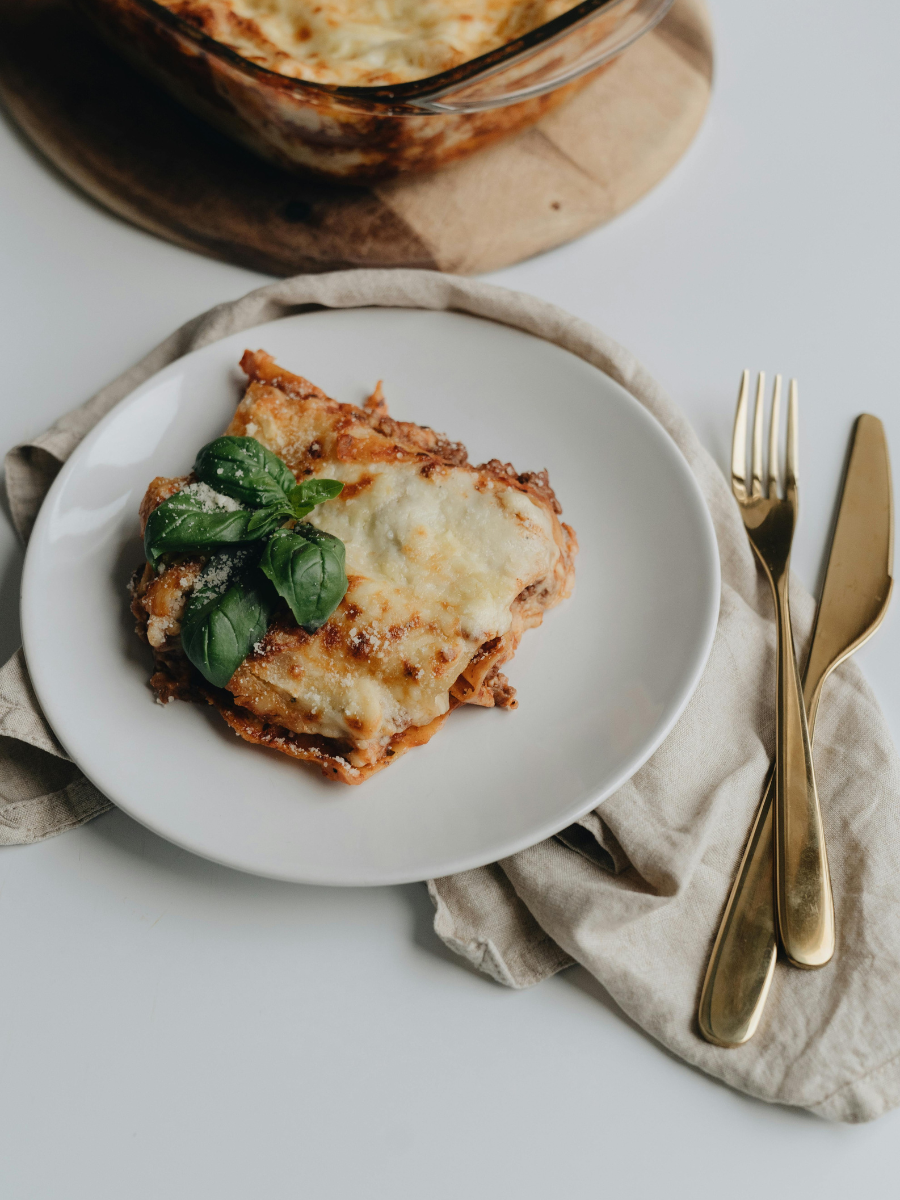 plate of homemade lasagna and casserole with fork and knife